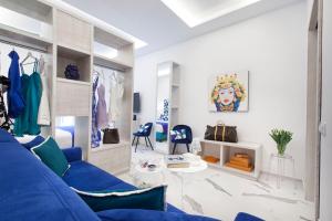 - un salon avec un canapé bleu et des chaises dans l'établissement Sorrento Lux Suite, à Sorrente