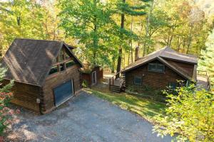a house with a garage next to a driveway at HOT TUB Charming & Chic Mountain Gem On Sleepy Creek in Berkeley Springs