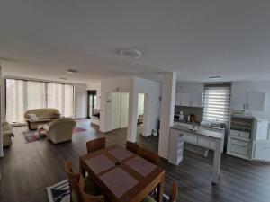 a large living room with a table and a kitchen at Apartman Paradiso in Pirot