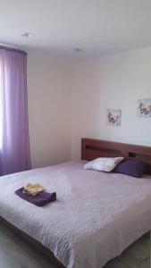 ein Schlafzimmer mit einem großen Bett mit einem lila Vorhang in der Unterkunft Green Park Domina apartment in Riga
