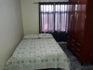 een kleine slaapkamer met een bed en een dressoir bij Casa Cabo Frio in Cabo Frio