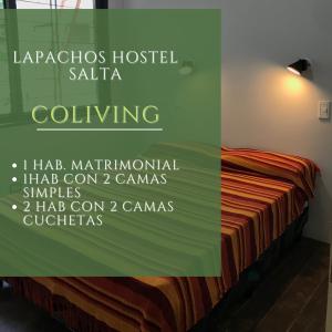 薩爾塔的住宿－Lapacho Hostel Salta Coliving，一间卧室,配有一张带标志的床