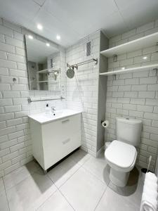 La salle de bains blanche est pourvue de toilettes et d'un lavabo. dans l'établissement AZ El Balcón a la Basílica III - en plena Plaza del Pilar!, à Saragosse