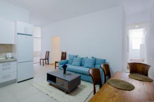 uma sala de estar com um sofá azul e uma mesa em Chio Kind Home em Chío