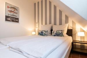 ein Schlafzimmer mit einem großen weißen Bett mit zwei Lampen in der Unterkunft Syltdomizil Tade, App 1 in Wenningstedt-Braderup