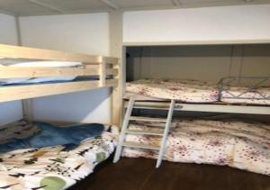 a bedroom with two bunk beds and a ladder at Guesthouse Yadokari - Vacation STAY 90101 in Imabari
