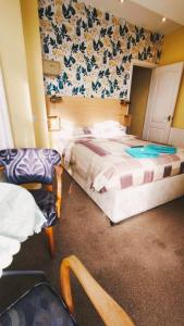 une chambre d'hôtel avec deux lits et une chaise dans l'établissement Dora Hotel, à Blackpool