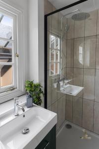 a bathroom with a sink and a shower at Luxe Courtyard Apartment for 4 Near Exeter City Centre in Exeter