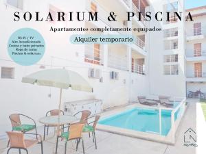 a magazine cover with a table and chairs and a swimming pool at Apartamentos Laguna de Navarro in Navarro