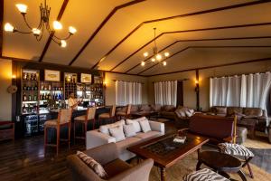ein großes Wohnzimmer mit Sofas und einer Bar in der Unterkunft Serengeti Sametu Camp in Serengeti-Nationalpark