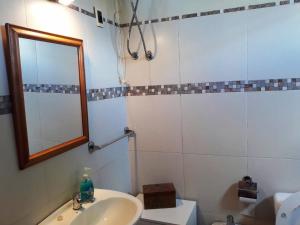 W łazience znajduje się umywalka i lustro. w obiekcie Excelente apartamento céntrico con cochera. w mieście Trinidad