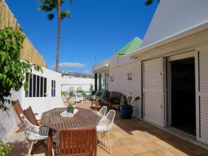a patio with a table and chairs and a building at Villa Nuria con piscina privada in Playa del Ingles