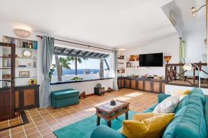 a living room with a blue couch and a large window at Casa Los Angeles in Tías