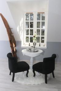 een tafel en 2 stoelen in een kamer met een raam bij La Rozeliere 