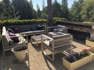 un patio con sofá, sillas y plantas en La Rozeliere, en Rozoy-le-Vieil