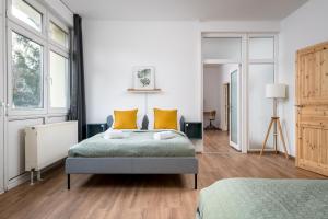 una camera da letto con un letto e due finestre di Ruhig Hell Wohnen im Grünen in Köpenick füßläufig zum Wasser 25min bis Flughafen a Berlino