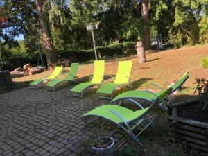 een rij groene en gele stoelen op een patio bij La Rozeliere 