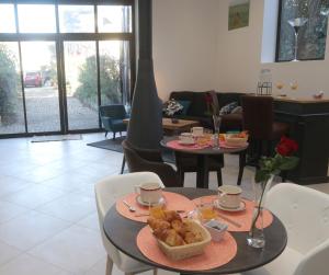 een woonkamer met twee tafels met eten erop bij La Rozeliere 