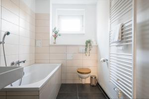ein Badezimmer mit einer Badewanne, einem WC und einem Waschbecken in der Unterkunft Ruhig Hell Wohnen im Grünen füßläufig zum Wasser 25min bis Flughafen in Berlin