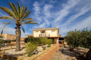 una casa con una palma di fronte di Hostal Rural Turre a Turre