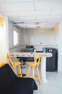 a kitchen with a table and two stools in a room at Nativo Kite House in La Boquilla
