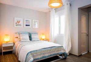 a bedroom with a bed with two lamps and a window at Dolmen de Viera in Antequera