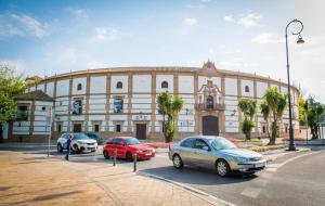 a building with three cars parked in a parking lot at Dolmen de Viera in Antequera