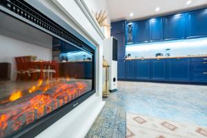 Apartament Południowy في رودا شلاسكا: موقد كبير في غرفة المعيشة مع خزانات زرقاء