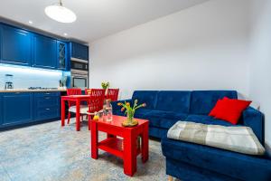 Apartament Południowy في رودا شلاسكا: غرفة معيشة مع أريكة زرقاء وطاولة حمراء
