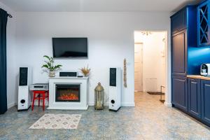a living room with a fireplace and a tv on the wall at Apartament Południowy in Ruda Śląska