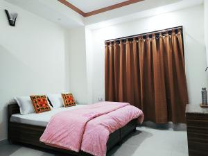 a bedroom with a bed and a brown curtain at Shimla Gypsy - Home Stay in Shimla
