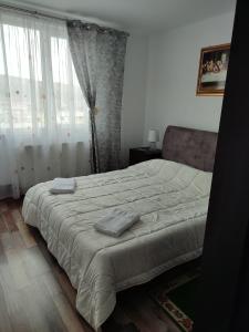 a bedroom with a bed with two towels on it at APARTAMENT HD ELI in Hunedoara