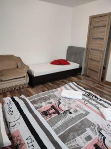 a bedroom with a bed and a chair and a rug at APARTAMENT HD ELI in Hunedoara
