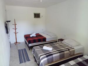 pokój z dwoma łóżkami i telewizorem w obiekcie Pousada Sol de Imbassai w mieście Imbassai