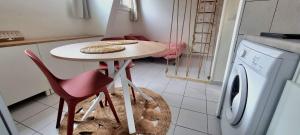 uma cozinha com uma mesa e uma máquina de lavar roupa em Studio équipé: TGV, RER, Paris, Saclay, ORLY em Massy