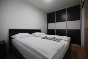 ブラチスラヴァにあるKoloseo residence 12th floor Lake view Free parkingのベッドルーム(黒いパネルの大きな白いベッド付)