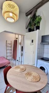 uma cozinha com uma mesa de madeira com cadeiras em Studio équipé: TGV, RER, Paris, Saclay, ORLY em Massy