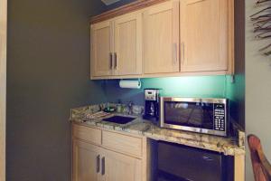 a kitchen with wooden cabinets and a microwave on a counter at Bella Paradiso 14 in Eureka Springs