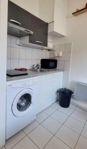 uma cozinha com uma máquina de lavar roupa e um lavatório em Studio équipé: TGV, RER, Paris, Saclay, ORLY em Massy