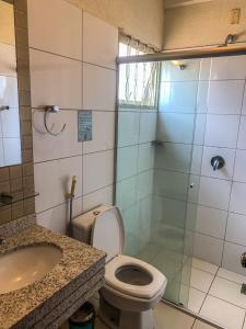 La salle de bains est pourvue de toilettes, d'une douche et d'un lavabo. dans l'établissement Hotel Piratininga Fernando Corrêa - Rondonópolis, à Rondonópolis