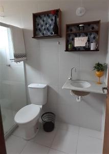 Baño blanco con aseo y lavamanos en Recanto Casa SOL en Barra de Jacuípe