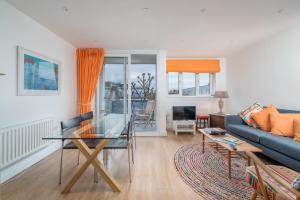a living room with a blue couch and a glass table at ALTIDO Cosy 2 bed, 2 bath flat with terrace, close to Tower Bridge in London