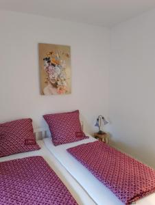 2 camas en una habitación con cojines morados en Ferienwohnung Am Geysirzentrum, en Andernach