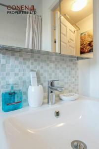 a bathroom counter with a sink and a mirror at CONEN Chafford Three Apartment in West Thurrock