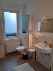 baño con lavabo y aseo y ventana en Ferienwohnung Am Geysirzentrum, en Andernach