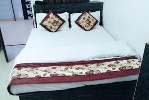 Una cama con dos almohadas encima. en Kaka Ji Palace By WB Inn en Agra