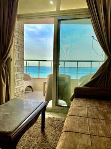 a bedroom with a view of the ocean from a balcony at Alexandria Luxury Apartments Sporting Direct Sea View in Alexandria