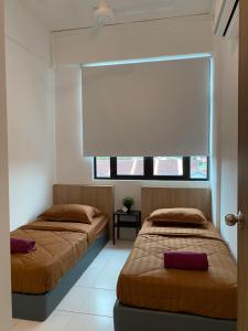 two beds sitting in a room with a window at The Sweet Escape @ Imperio Professional Suite in Alor Setar