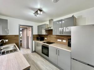 a kitchen with white cabinets and a white refrigerator at Bramhall House - Great for Contractors or Family Holidays in Cleethorpes