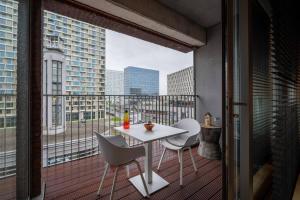 a balcony with a table and chairs and a view of a city at London 993 Loft 402 in Antwerp